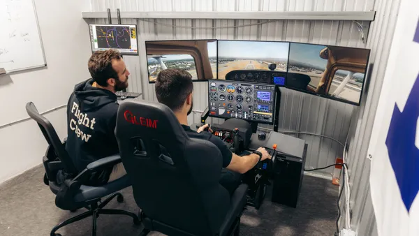 Instructor sitting beside a pilot flying an approach in the Gleim BATD simulator at LA Flight Academy