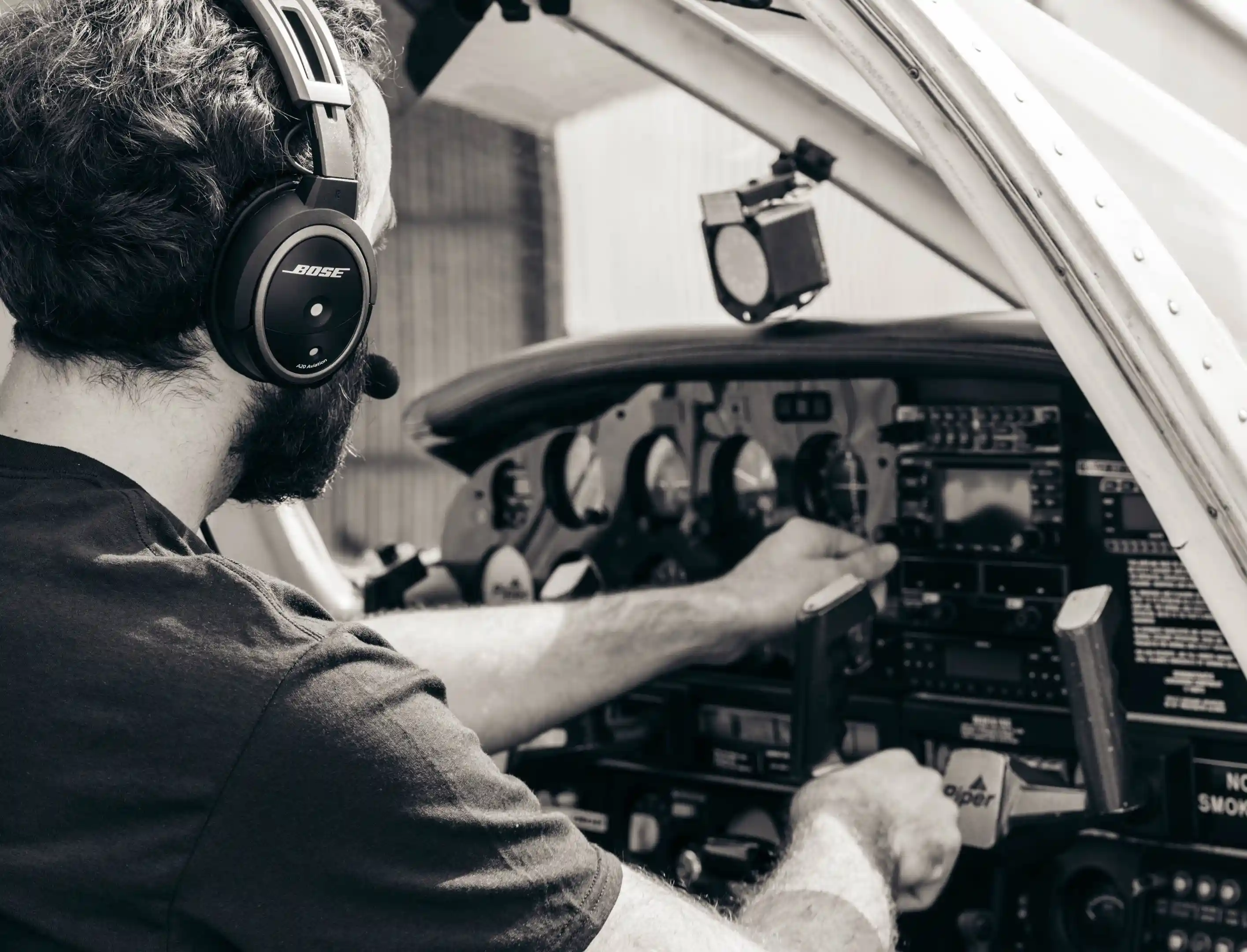 la flight academy los angeles flight school cfi checking controls of piper archer plane in black and white