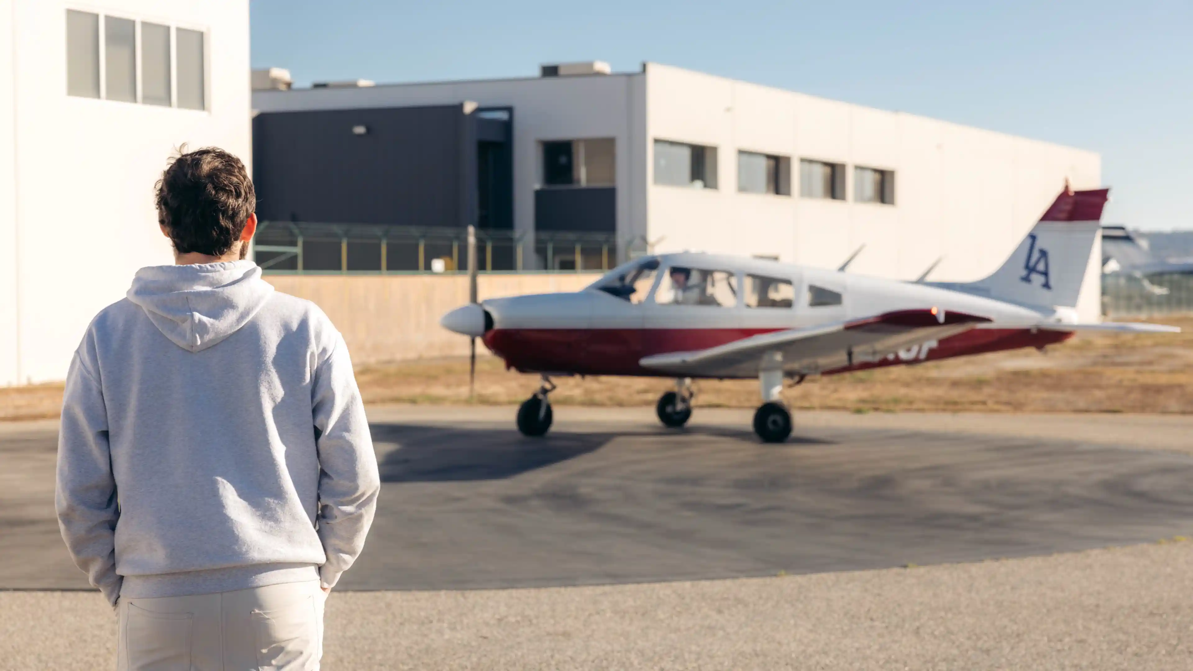 la flight academy los angeles flight school cfi watching student maneuver plane piper cherokee outside hangar