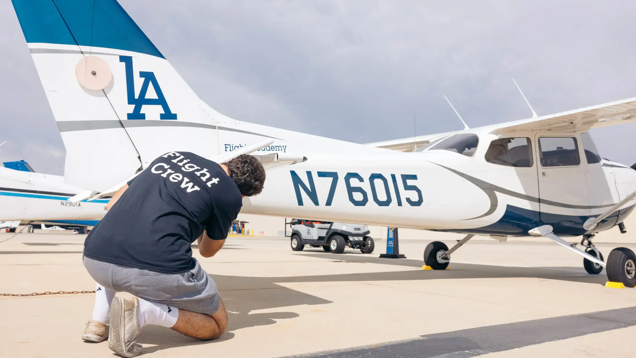 Flight instructor inspecting a Piper aircraft before flight at LA Flight Academy