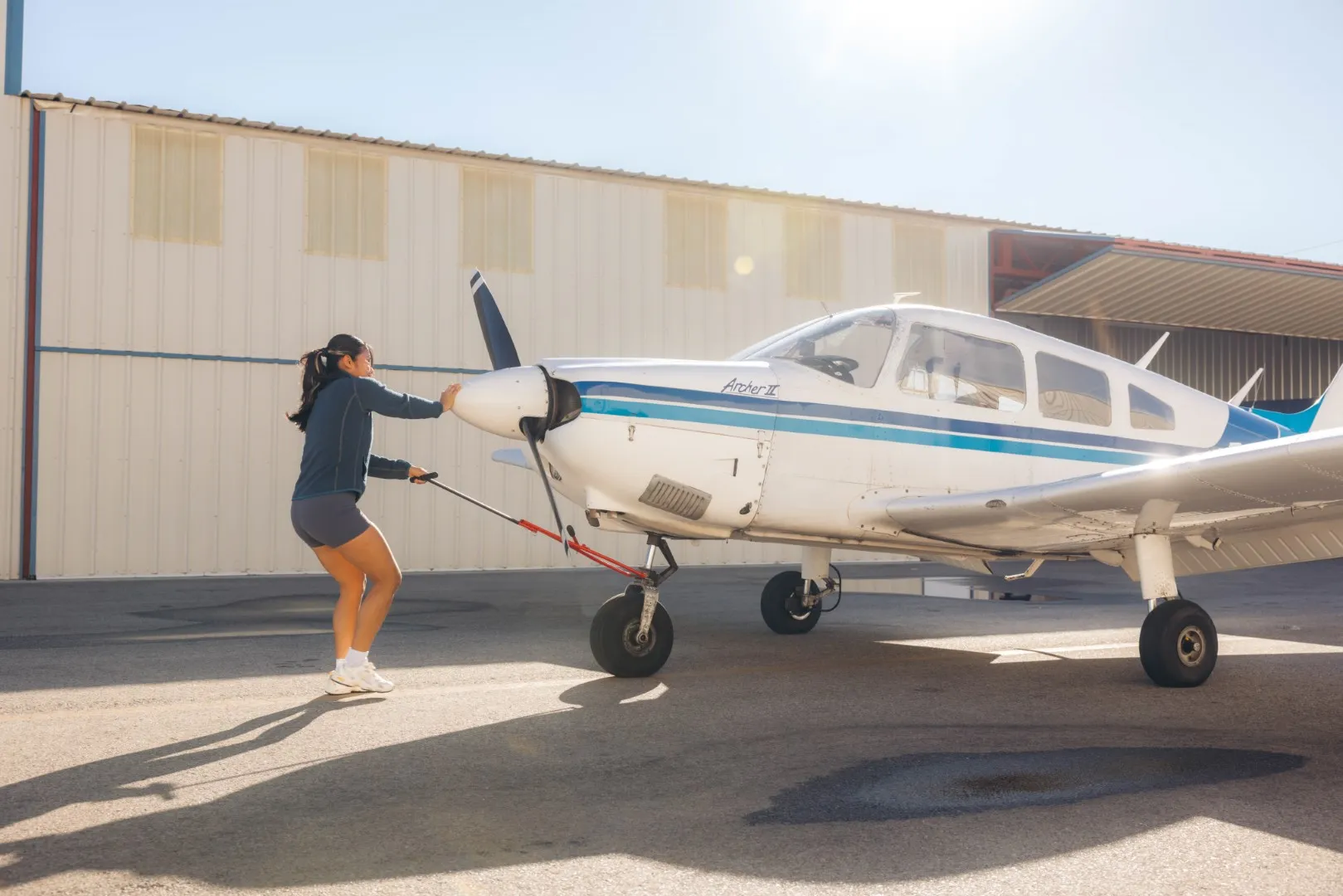 LA Flight Academy student pulling plane out of hangar