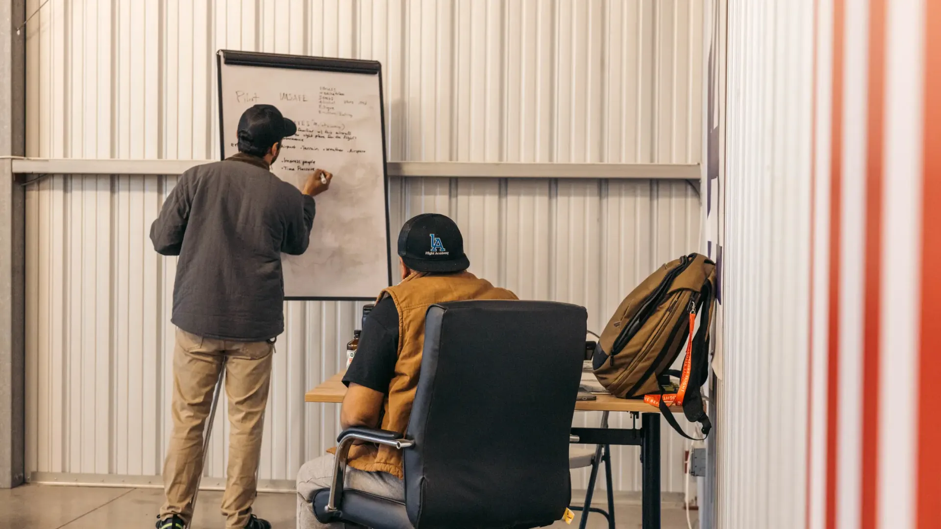 LA Flight Academy instructor writing on a whiteboard while a student takes a ground lesson