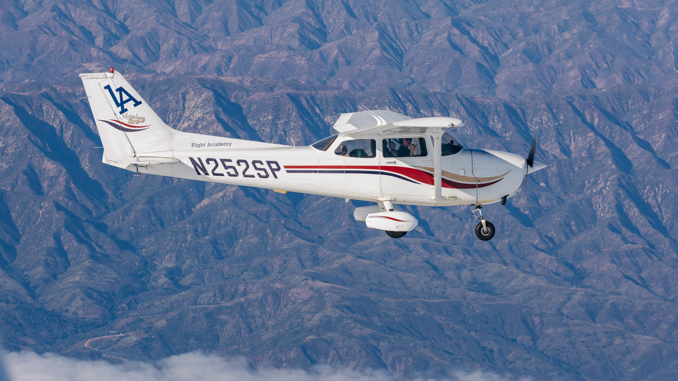 Commercial pilot career path showing progression from PPL through airline employment, with students in front of training aircraft at Van Nuys Airport