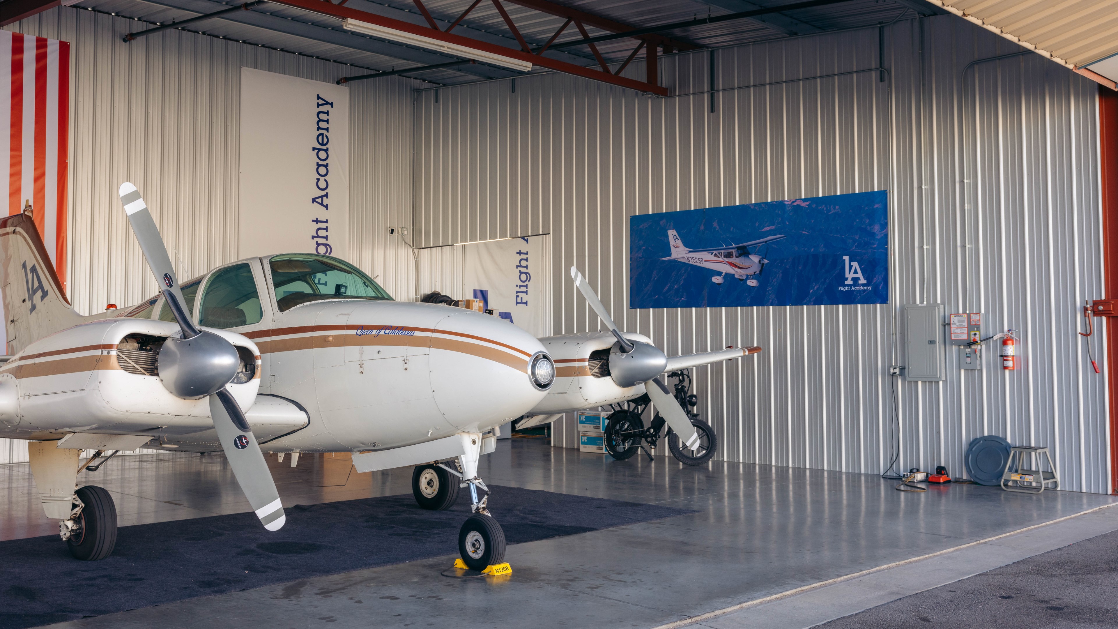 Twin-engine training aircraft inside a hangar at LA Flight Academy