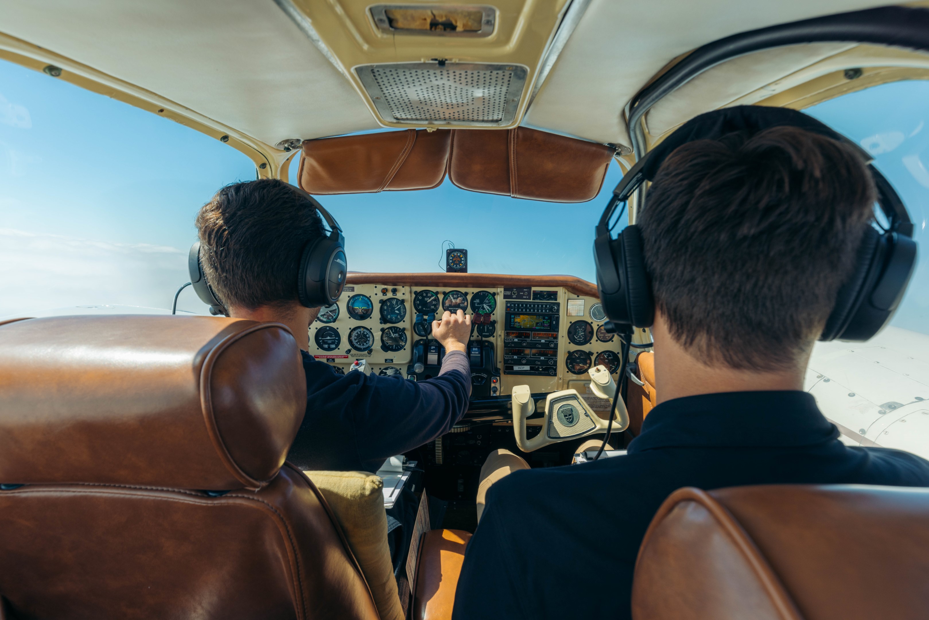 A student pilot and flight instructor managing twin-engine operations from the cockpit of the Beechcraft Baron