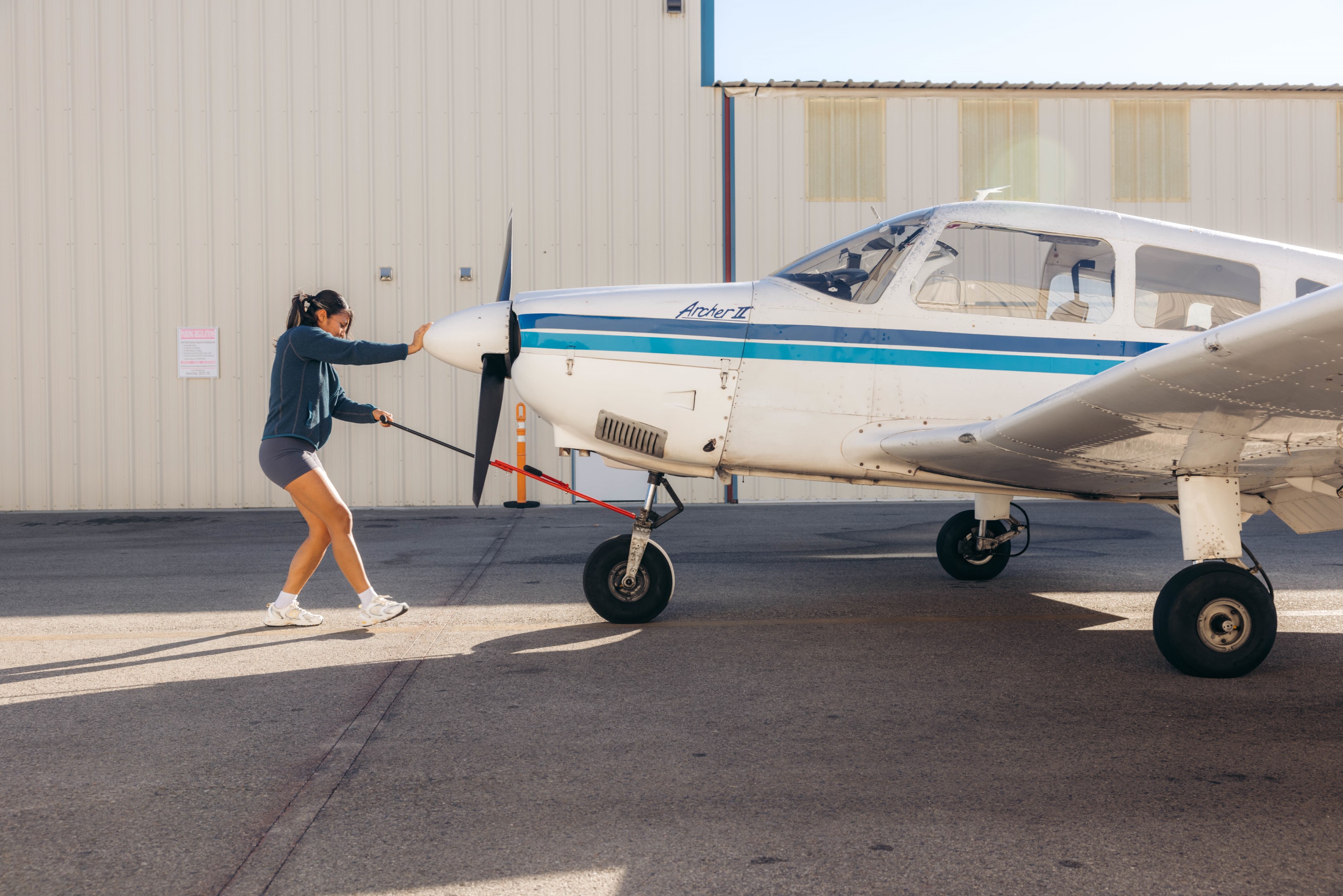 A student pilot preparing a Piper Archer plane for a flight lesson at Van Nuys Airport
